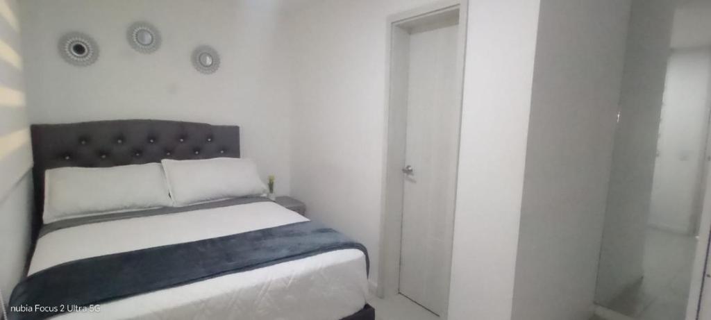 a white room with a bed and a door at Room cerca al aeropuerto #5 in Bogotá