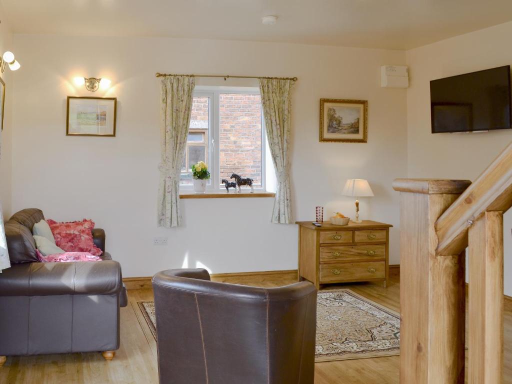a living room with a couch and a window at Bess's Cottage in Middlewich