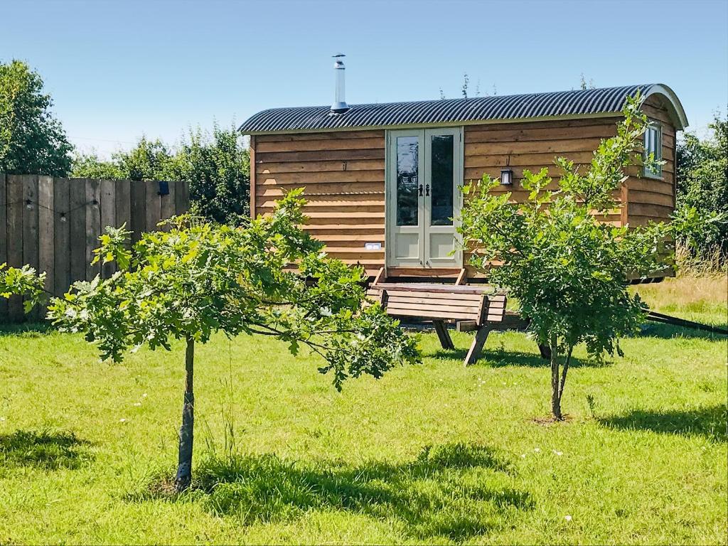 a wooden cabin in a field with two trees at Ryeland Hut - Qu7632 in Messing