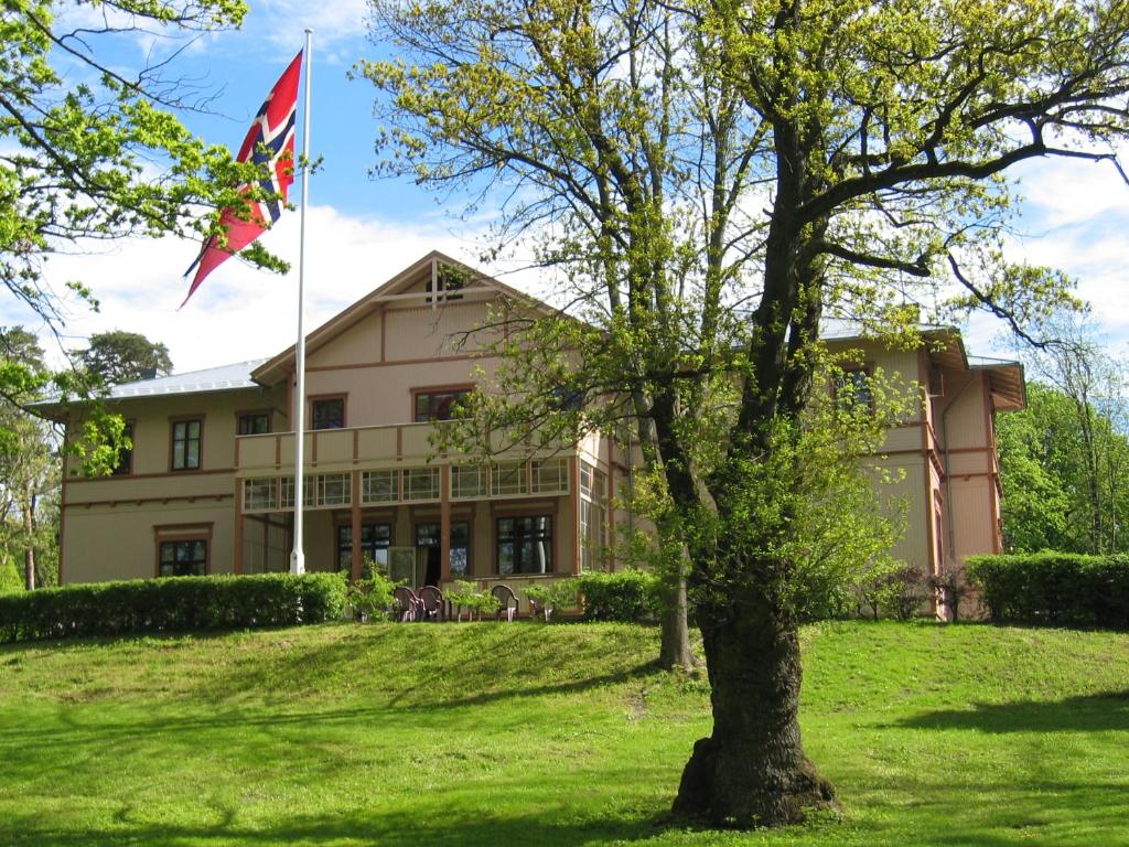 um edifício com uma bandeira à sua frente em Sjømilitære Samfund em Horten