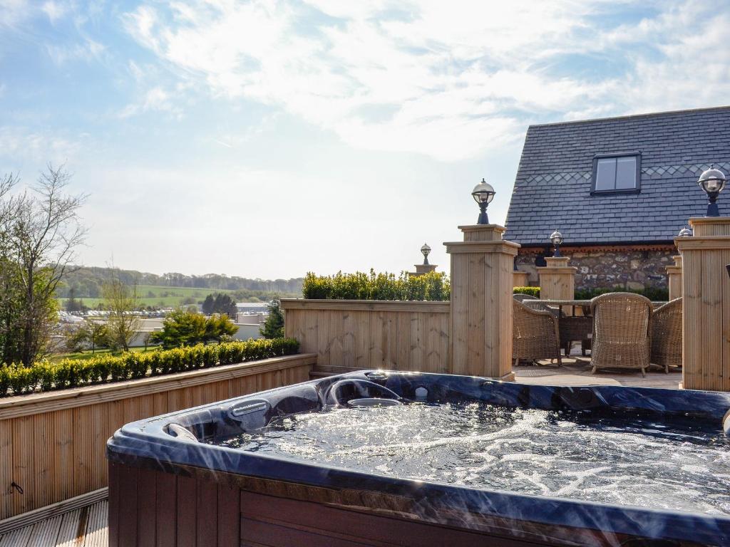 a hot tub on the deck of a house at Hillend Stables in Dalry