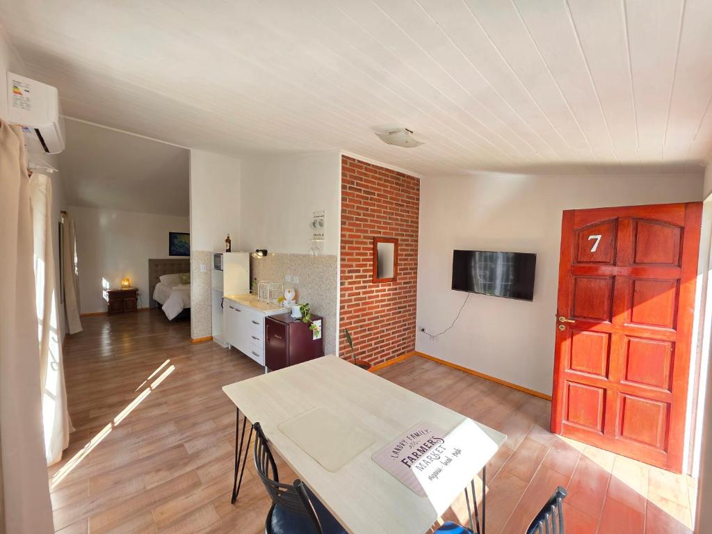 a living room with a table and a brick wall at La Margarita Aparts - Solo 2 Pax in Mina Clavero