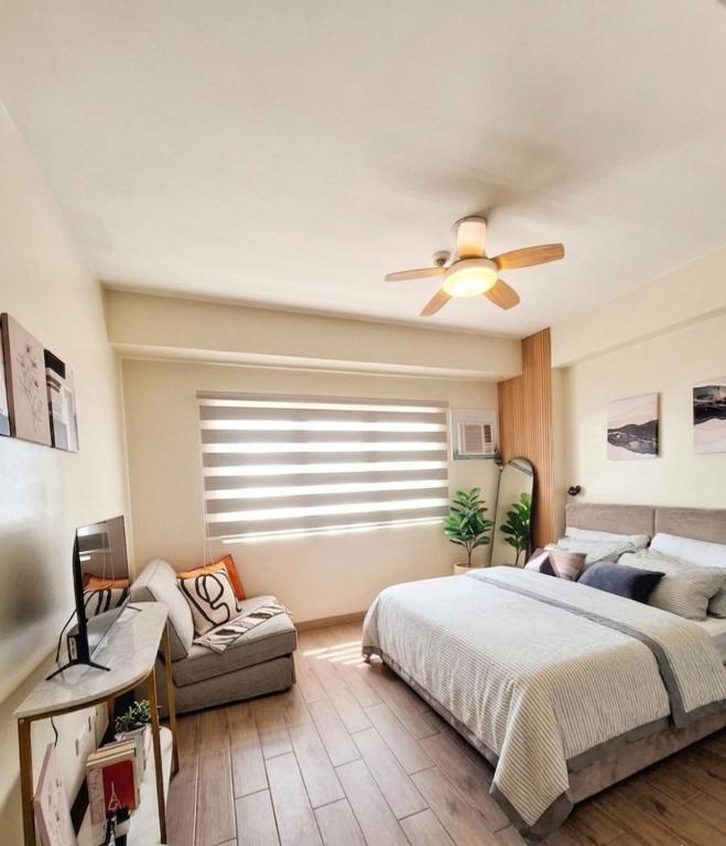 a bedroom with a bed and a ceiling fan at Studio 7C at One Regis in Bacolod