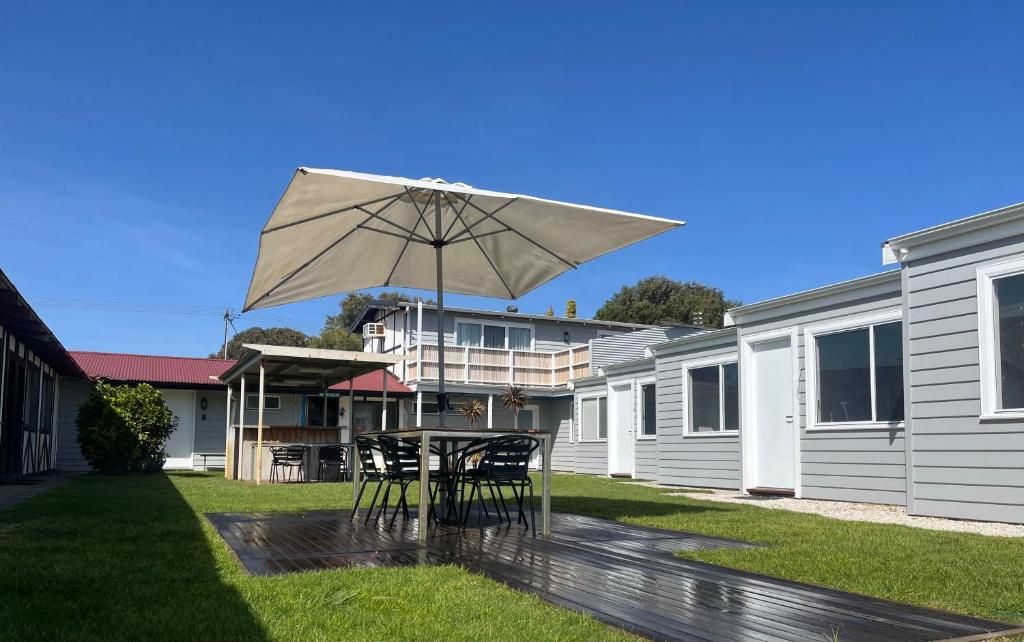 a patio with a table and an umbrella at Robe Nampara Cottages in Robe