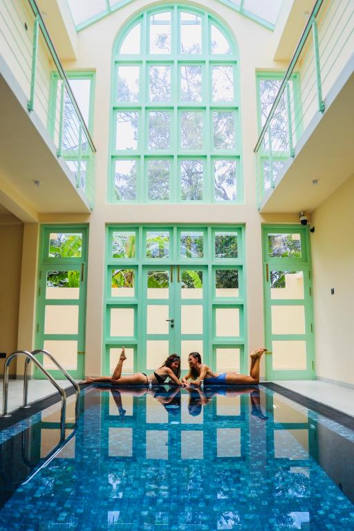 two women laying on the floor of a swimming pool at Allude Villa Weligama in Weligama