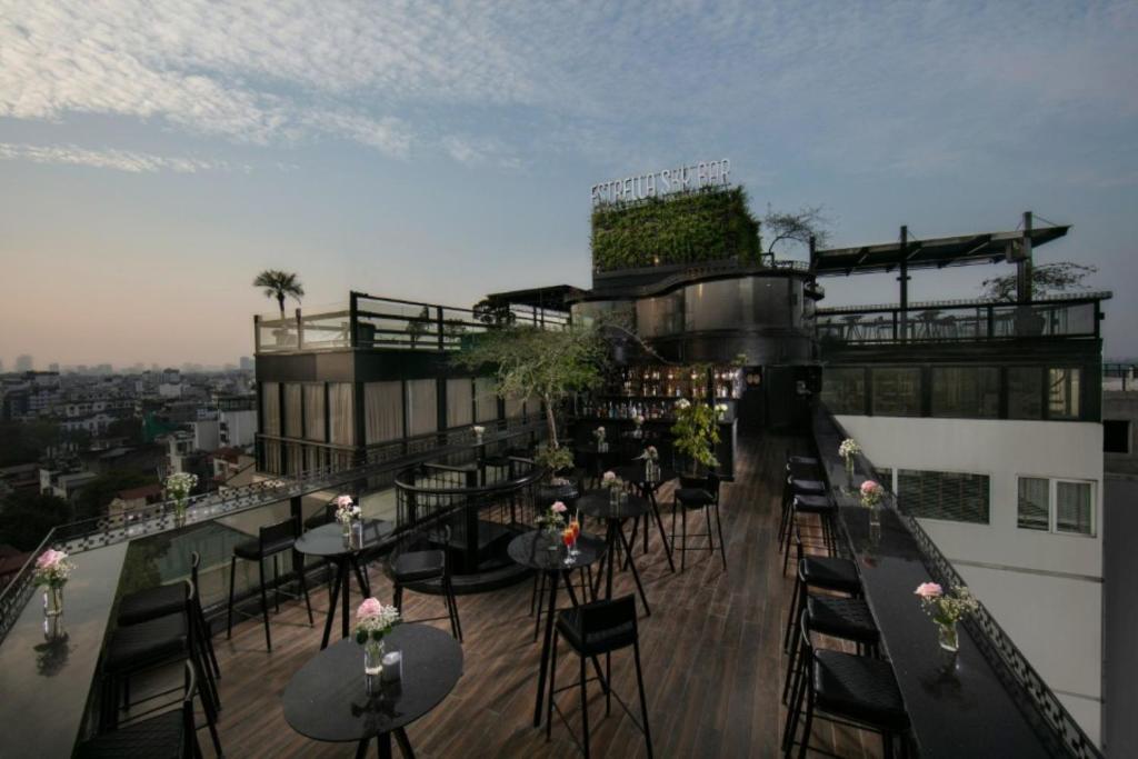a balcony with tables and chairs on a building at La Nueva Boutique Hotel Hanoi & Spa in Hanoi