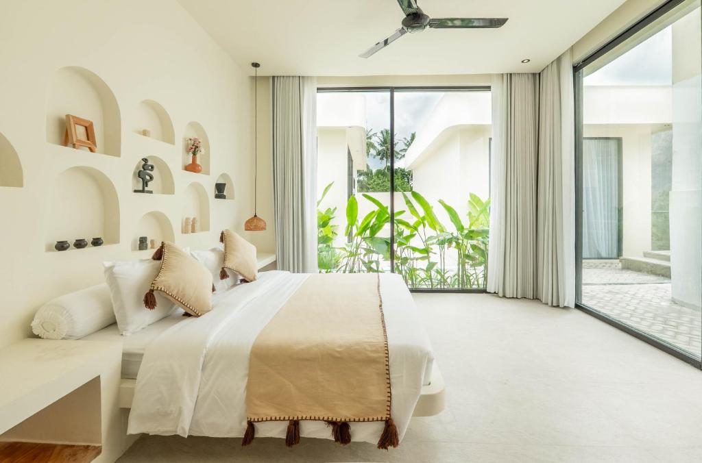 a bedroom with a bed and a large window at Soma House - Adults Only in Kuta Lombok