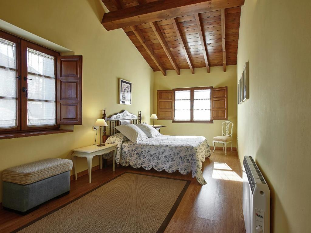 a bedroom with a bed and a chair and windows at Mansion in Nava with Pool & Terrace in Nava
