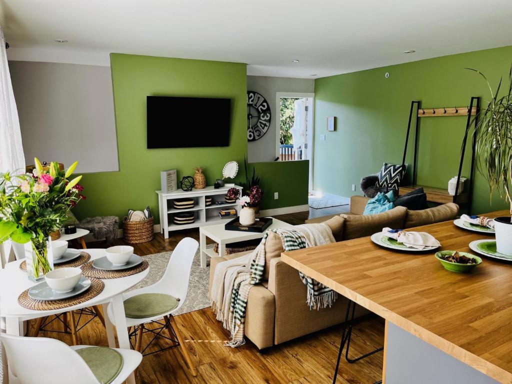 ein Wohnzimmer mit grünen Wänden und einem Tisch in der Unterkunft Modern Maple Flat in Maple Ridge District Municipality