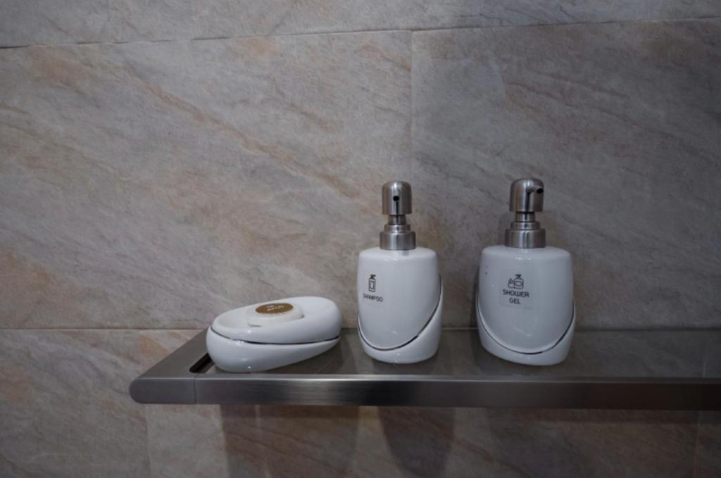 two electric toothbrushes sitting on a shelf in a bathroom at La Cha Cha Residence in Ban Thalat Choeng Thale