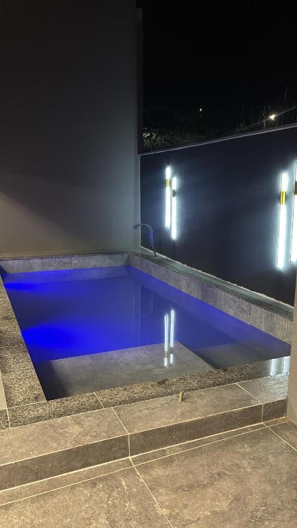 a swimming pool at night with blue illumination at Vista Bela Guesthouse in Barra do Garças