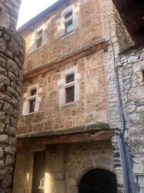 an old stone building with windows and a door at L'impasse de la courtasse in Sainte-Énimie