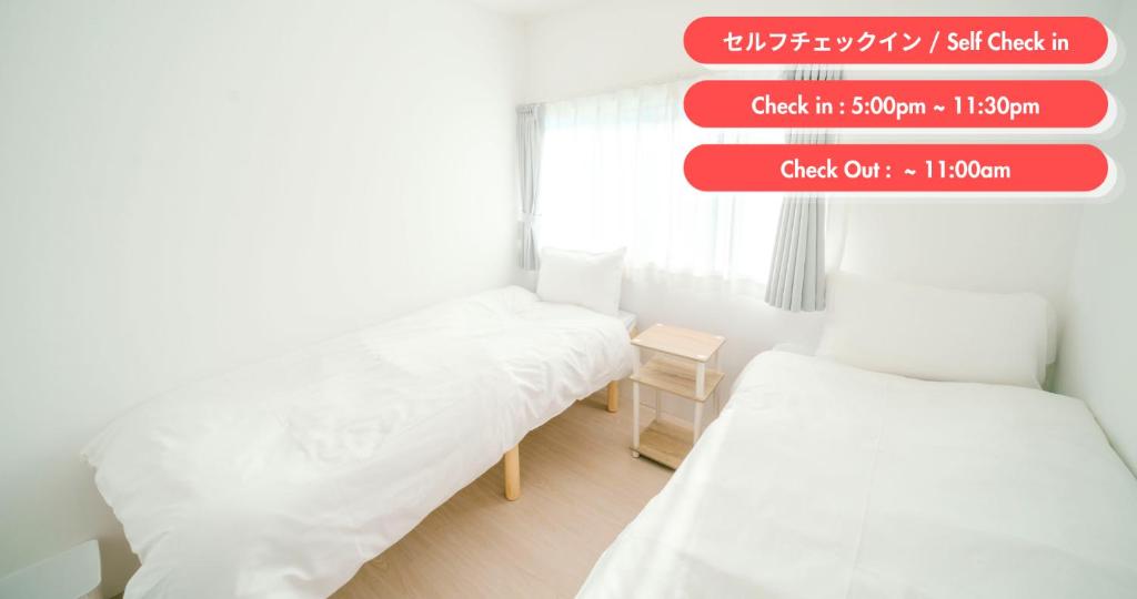 two beds in a small room with a sign above them at TRANSIT HOSTEL Cafe and Bar in Izumi-Sano