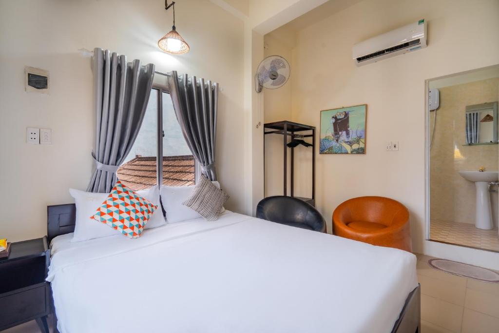 a bedroom with a white bed with a canopy at Y's La House in Hoi An