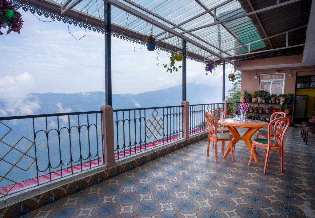 a balcony with a table and chairs and a view at Himavati Retreat in Darjeeling