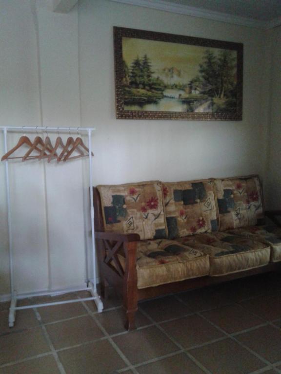 Una sala de estar con un sofá y un cuadro en la pared. en Apartamento Exclusivo, en Campo Grande