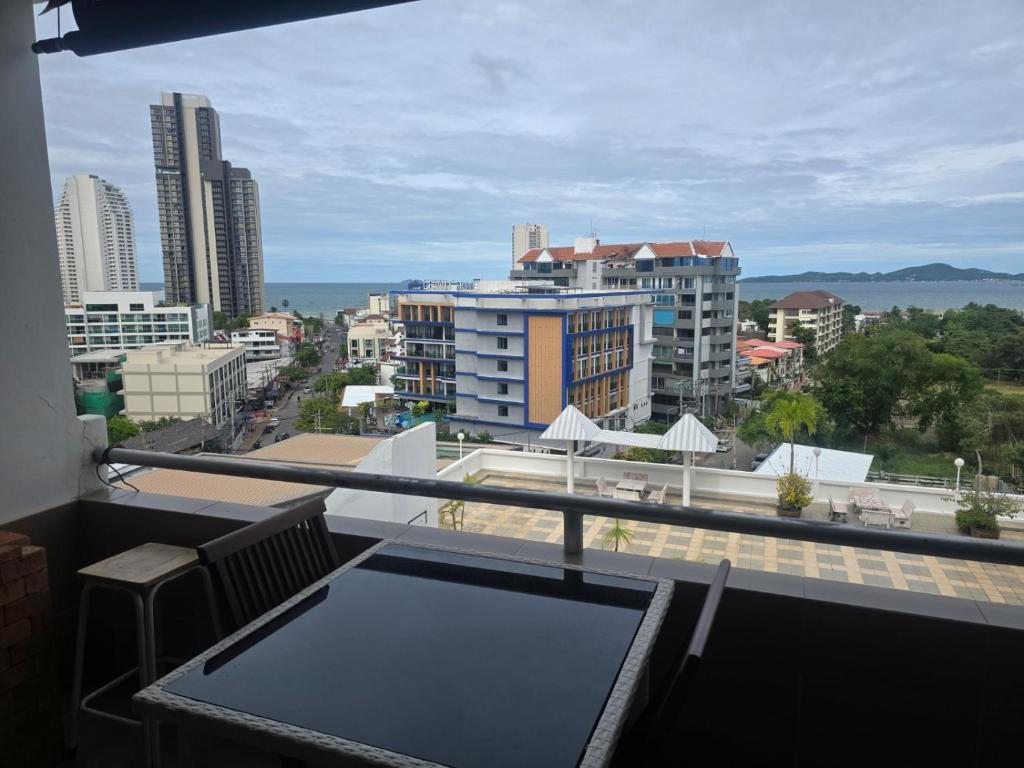a balcony with a table and a view of a city at Jomtien Hill Resort Pratamnak in Pattaya South
