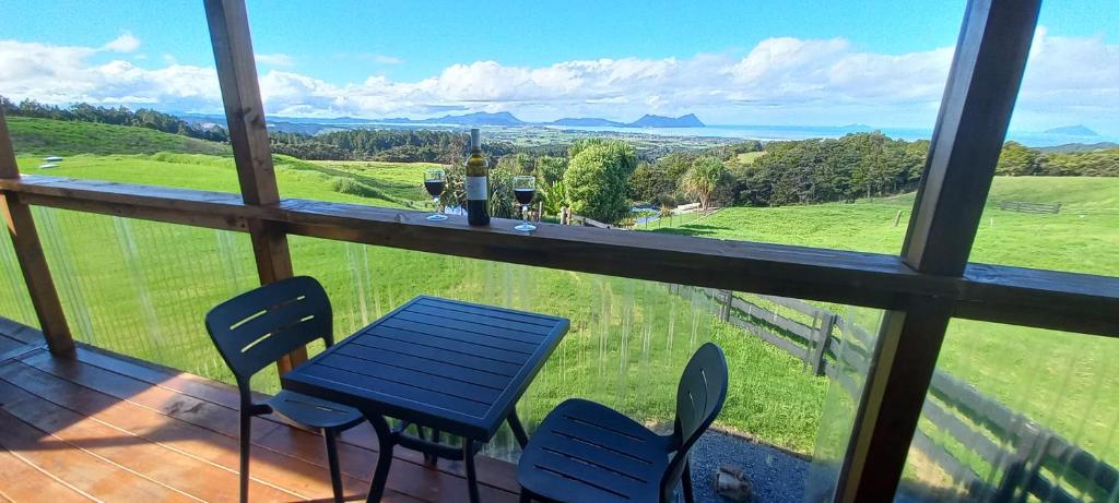 a table and chairs on a balcony with a view at Bream Bay Views in Ruakaka