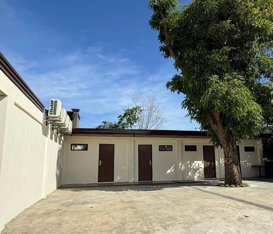 a building with two garage doors and a tree at JlRC Apartelle in Santa Catalina