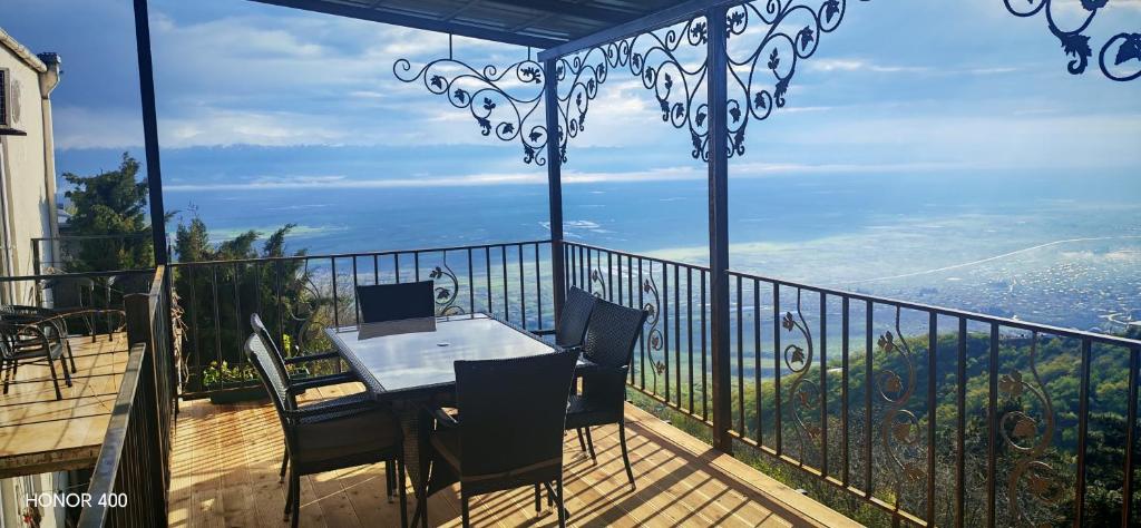 a table and chairs on a balcony with a view at Abramichi Guest House in Sighnaghi