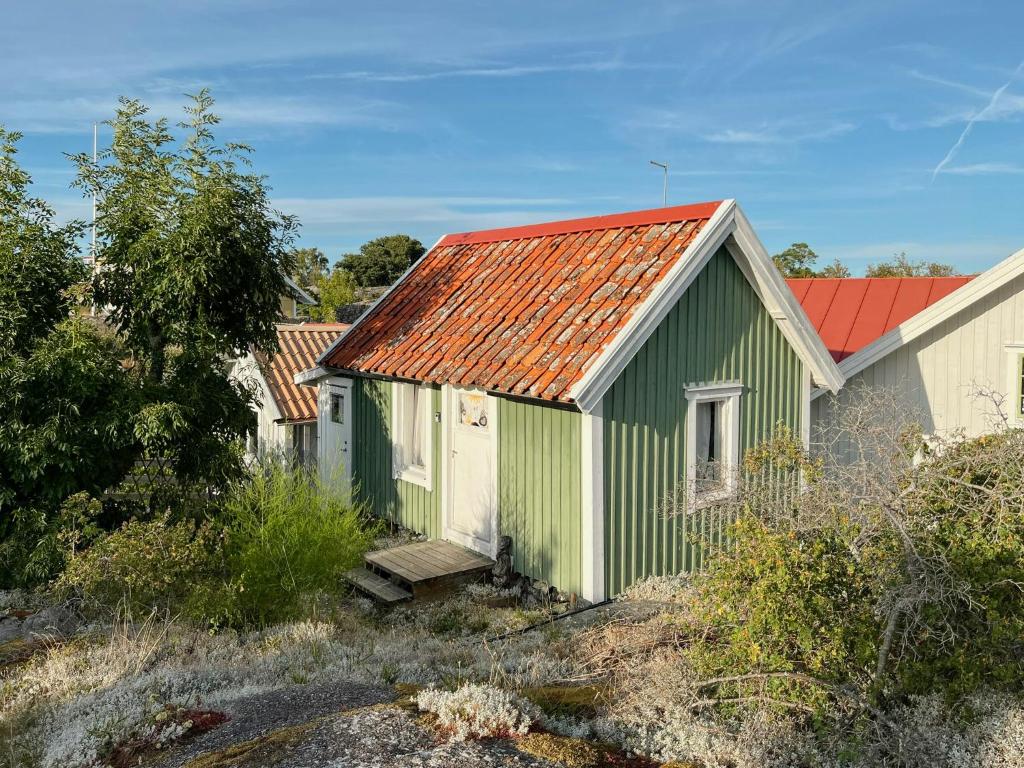 a green and white building with a red roof at Historic Cabin By Landsort Lighthouse in Nynäshamn