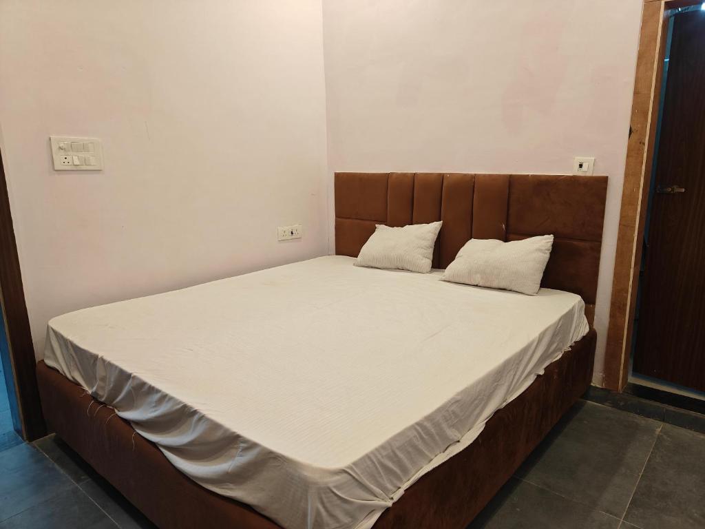 a large bed with white sheets and pillows on it at Sunrise stay in Mathura