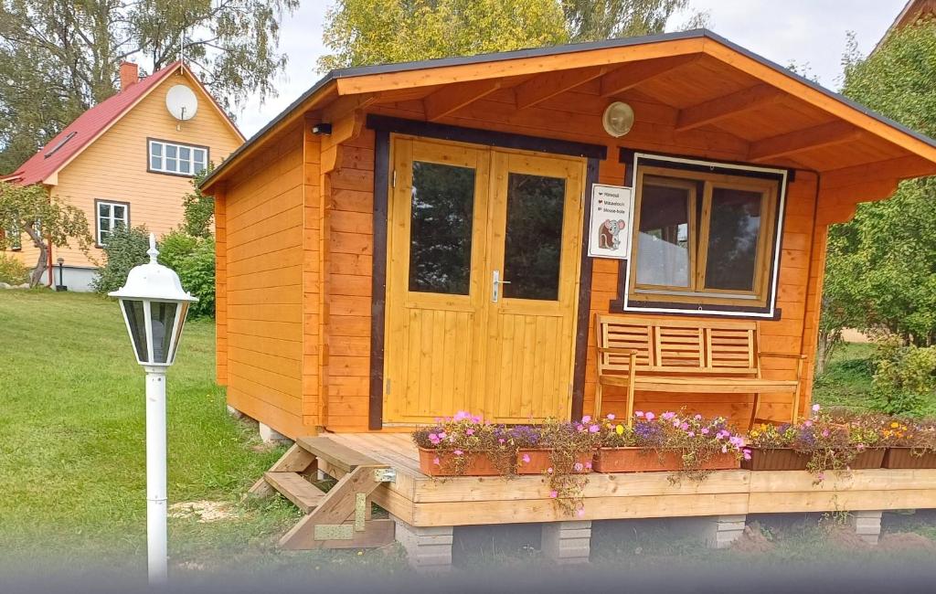 a tiny house on a bench with flowers in front at Chalet Glamping in Myza Igaste