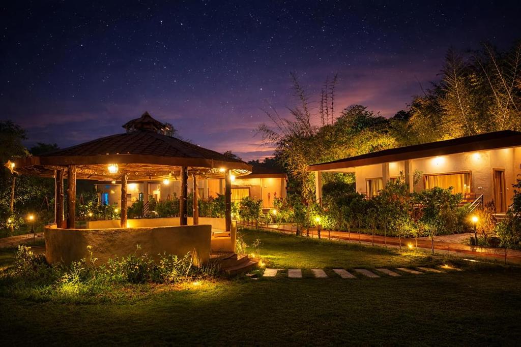 a house with a gazebo at night with lights at Bandhav Moonlight Resort in Tāla
