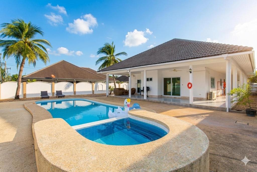 a villa with a swimming pool in front of a house at D2 Private Pool Villa Snooker Family & Friends in Hua Hin