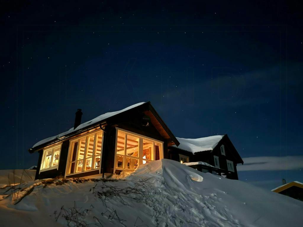 a house on top of a pile of snow at night at Renovated Mountain Cabin With Mountain Views in Al