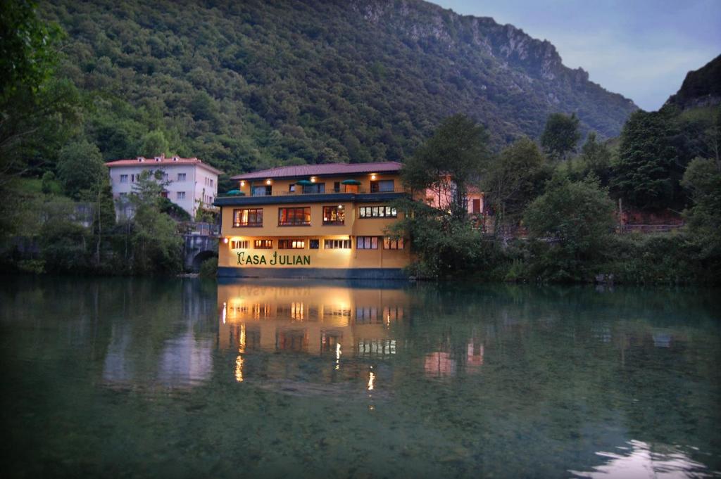 a large house on the water in a river at Hotel Casa Julián in Peñamellera Alta