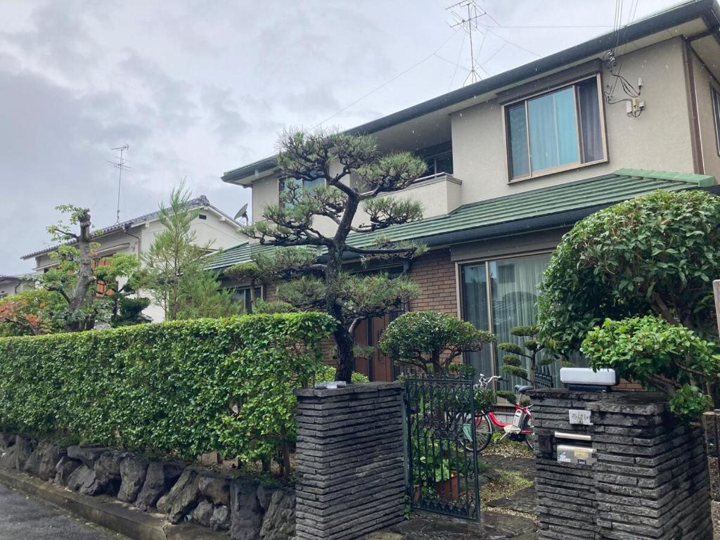 a house with a tree in front of it at Private Inn Ray in Nara