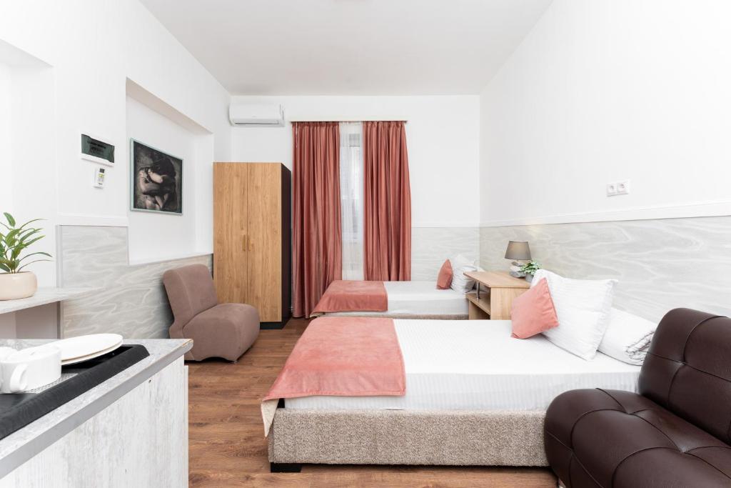 a hotel room with two beds and a couch at Budget Hotel Rooms In Yerevan in Yerevan