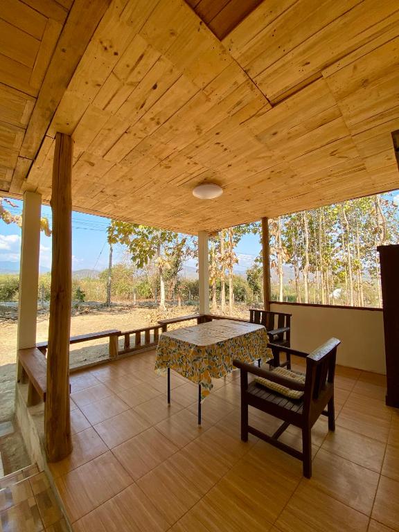 a large porch with a table and chairs and a view at Teak Soul Home in Ban Na Toeng Nai