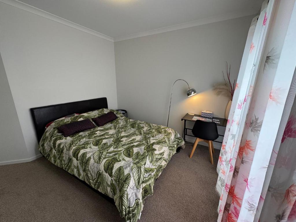 a bedroom with a bed and a desk in it at Quiet and Cozy Room in Geelong