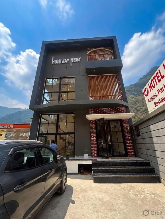 a car parked in front of a library next to a building at Hotel Highway Nest in Chamba