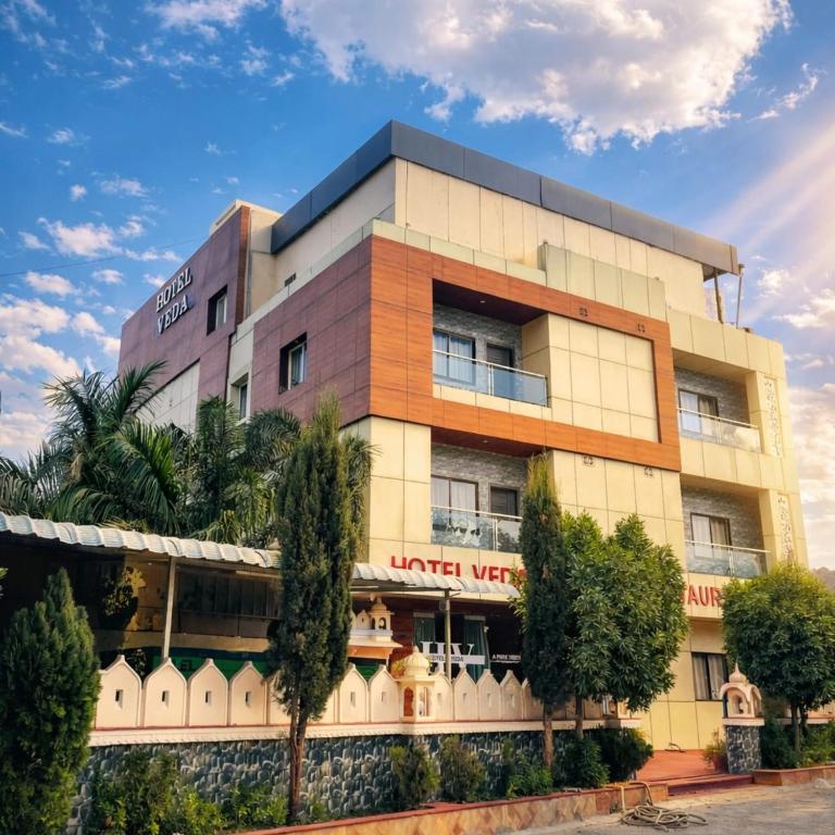 a building with trees in front of it at Veda Resort in Udaipur