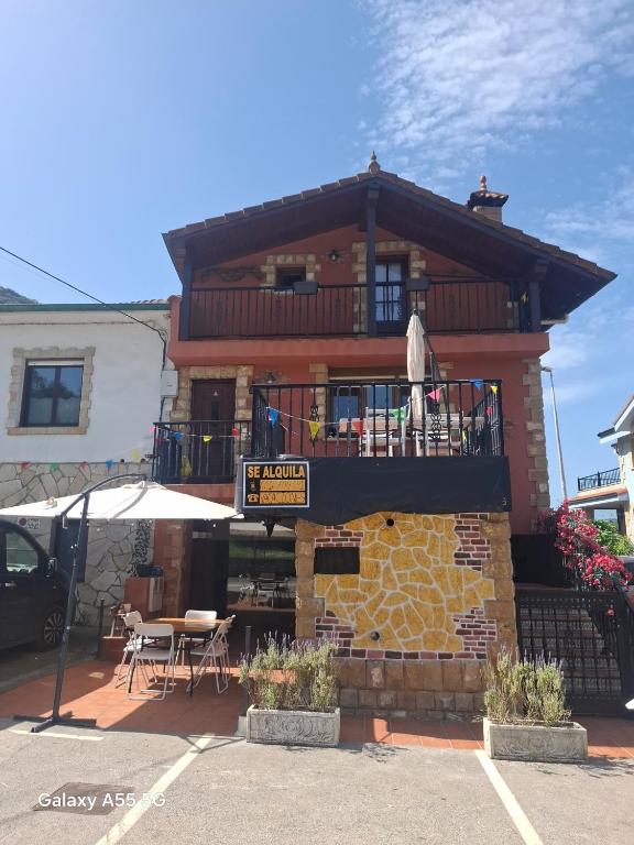 a building with a balcony and a table and chairs at El Fumvial in Arnuero