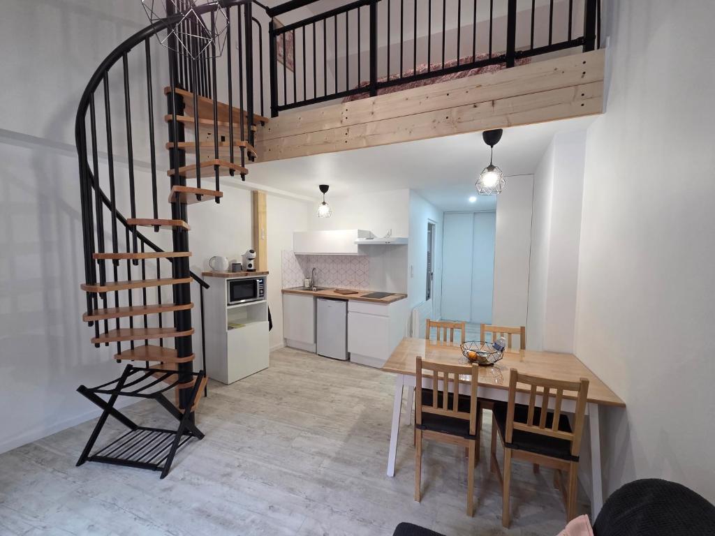 a kitchen and dining room with a spiral staircase at Nuit douce au LYS in Phalsbourg