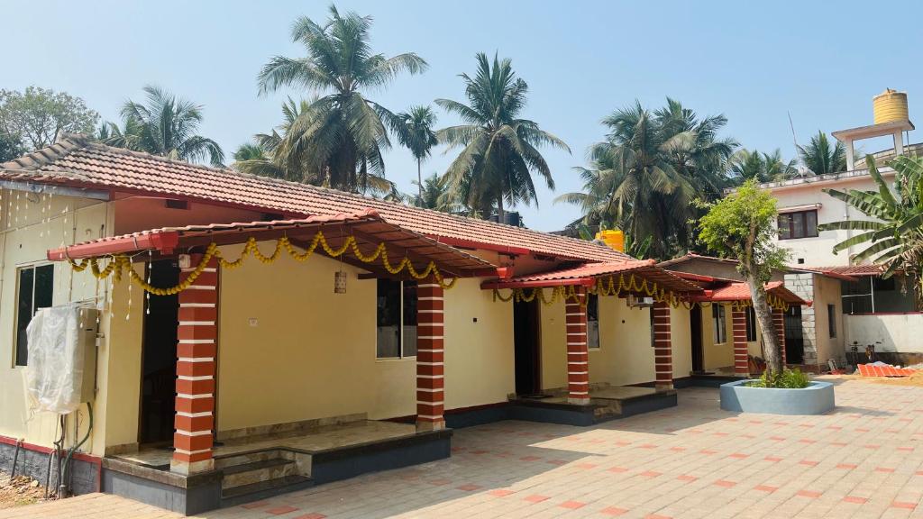 a row of houses with palm trees in the background at LX premium cottages - Udupi in Udupi