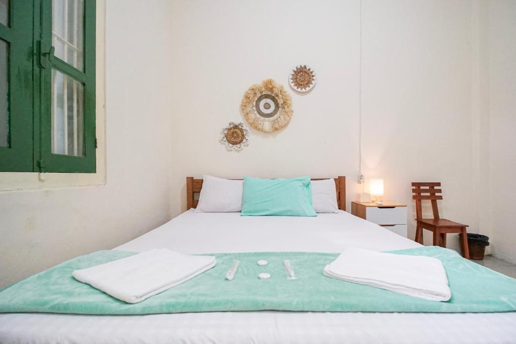 a bedroom with a bed with two towels on it at Homestay Putri Kencono in Yogyakarta