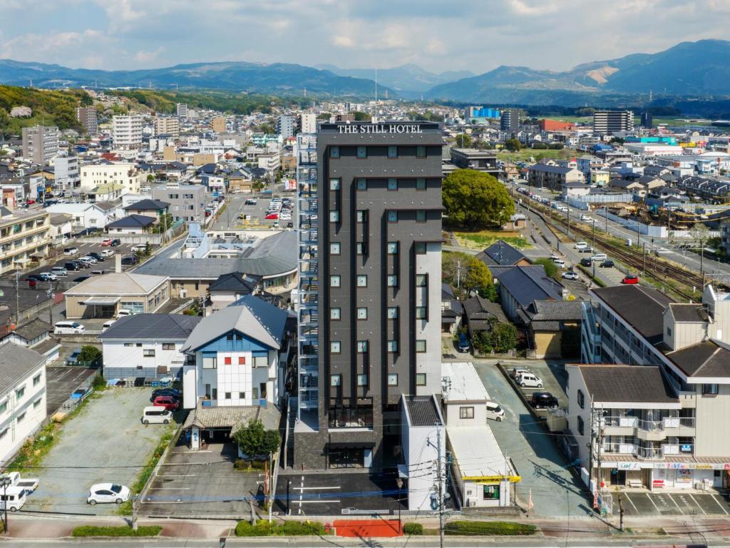 eine Luftaufnahme einer Stadt mit einem hohen Gebäude in der Unterkunft THE STILL HOTEL - Opening April 3, 2026 in Ozu