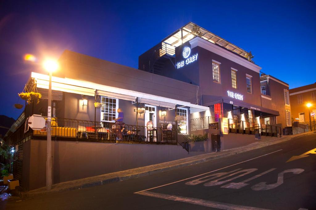 un bâtiment avec un restaurant dans une rue la nuit dans l'établissement The Grey Hotel, au Cap