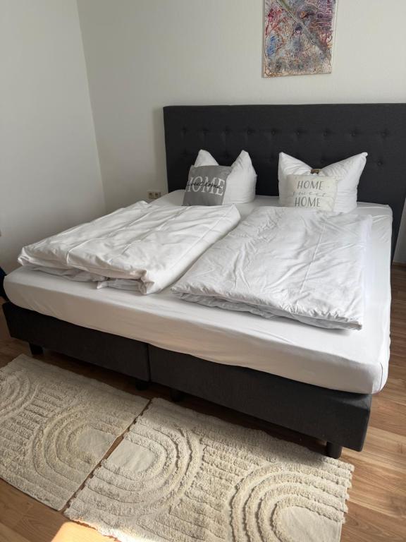 a bed with white sheets and pillows on it at Apartment Plini in Montabaur