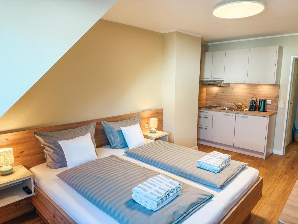 a bedroom with two beds and a kitchen at Apartmenthaus Leuchtfeuer in Norderney