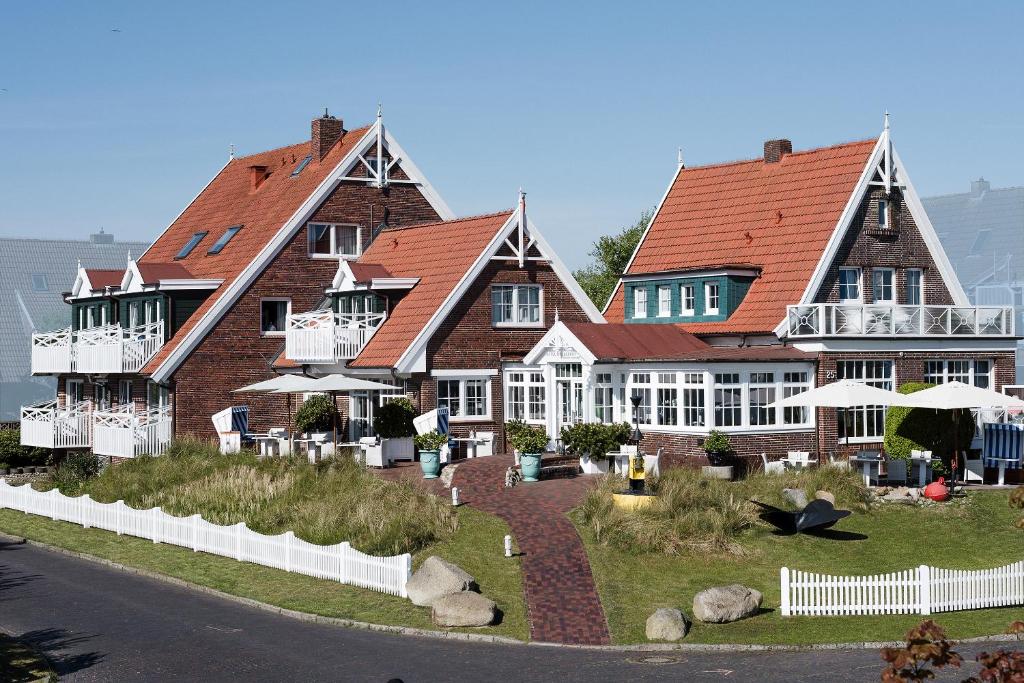 a large house with a garden in front of it at Hotel Norderriff in Langeoog