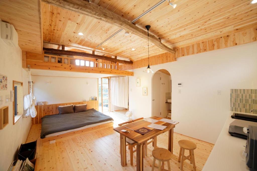 a bedroom with a bed and a table in a room at まるしっぽ邸-Marushippotei-連泊20パーセントOFF!Onsen,BBQ,hammock,national park,home theater in Murautsuri