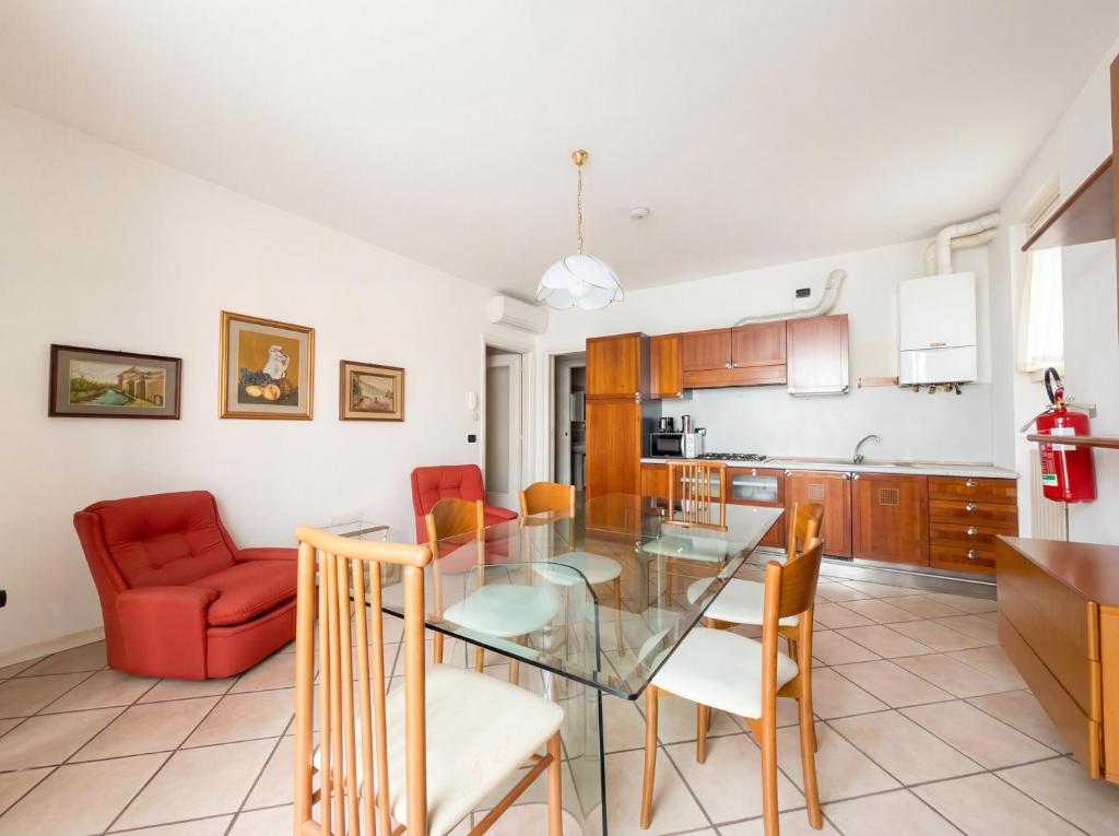 eine Küche und ein Esszimmer mit einem Glastisch und Stühlen in der Unterkunft Central Duplex in Iseo - 2 Bedrooms - Private Parking & WiFi in Iseo