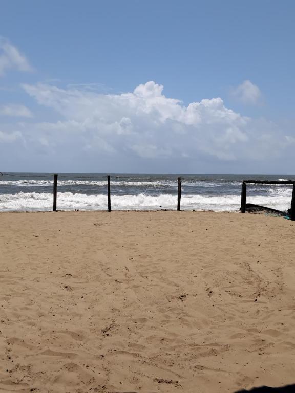 a sandy beach with poles in the ocean at Avish Dubbansasi Beach stay Resort Gokarna in Gokarn