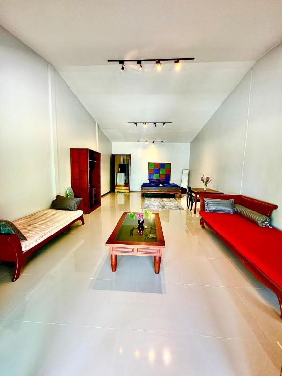 a large living room with red couches and a table at Amazing beach apartment Phuket in Phuket